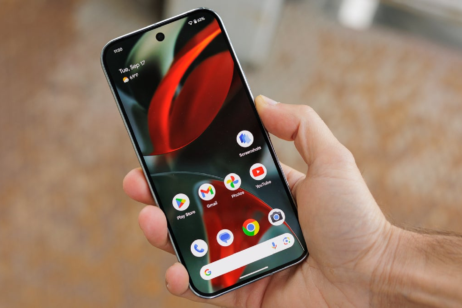 A photo of a person holding a Google Pixel phone running Android, a Linux derived operating system.